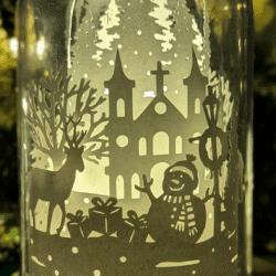 Veilleuse artisanale en papier sous cloche, scène hivernale avec renne et forêt enneigée, création lumineuse poétique faite main à Lille.